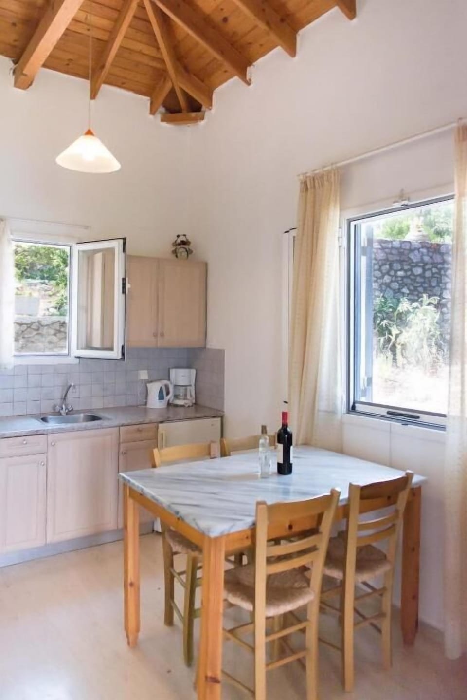 Bright open-plan dining and living area with traditional wooden ceiling and plenty of natural light.
