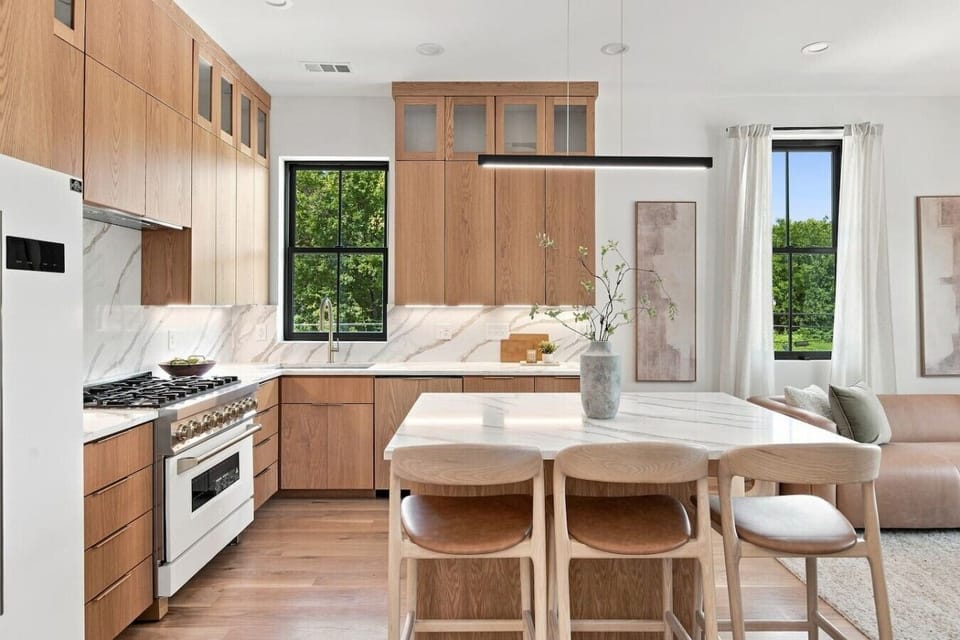 Fully equipped kitchen for all of your cooking needs, including white oak cabinetry and millwork. The spacious kitchen island includes additional seating for 3. This room opens up into the living room and dining area.