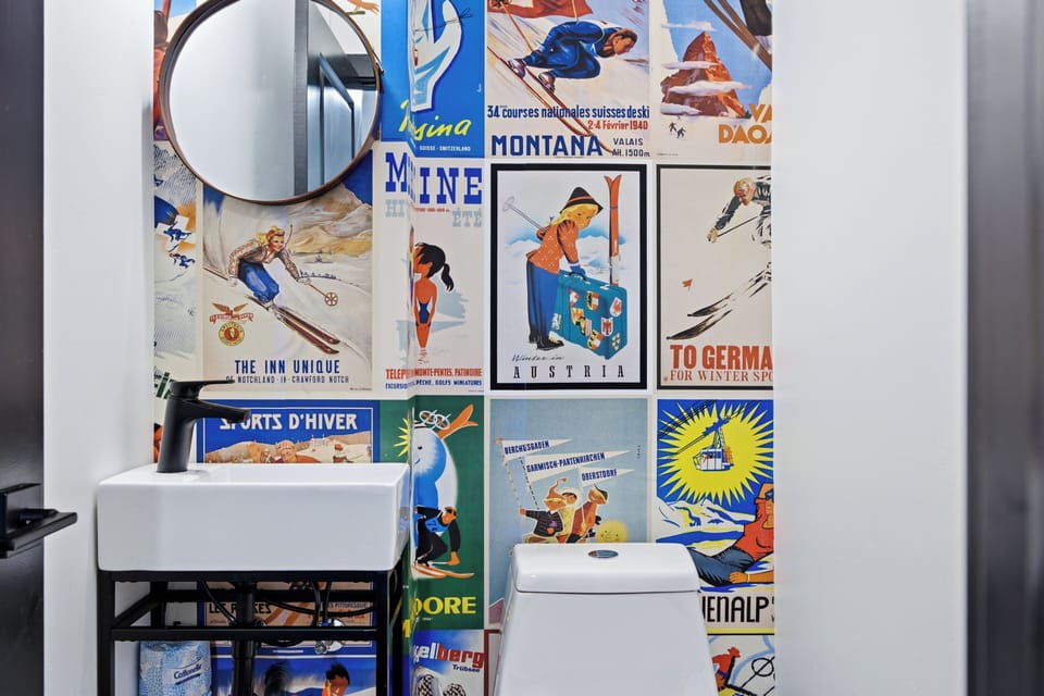Chic powder room with vintage ski poster wall and modern finishes