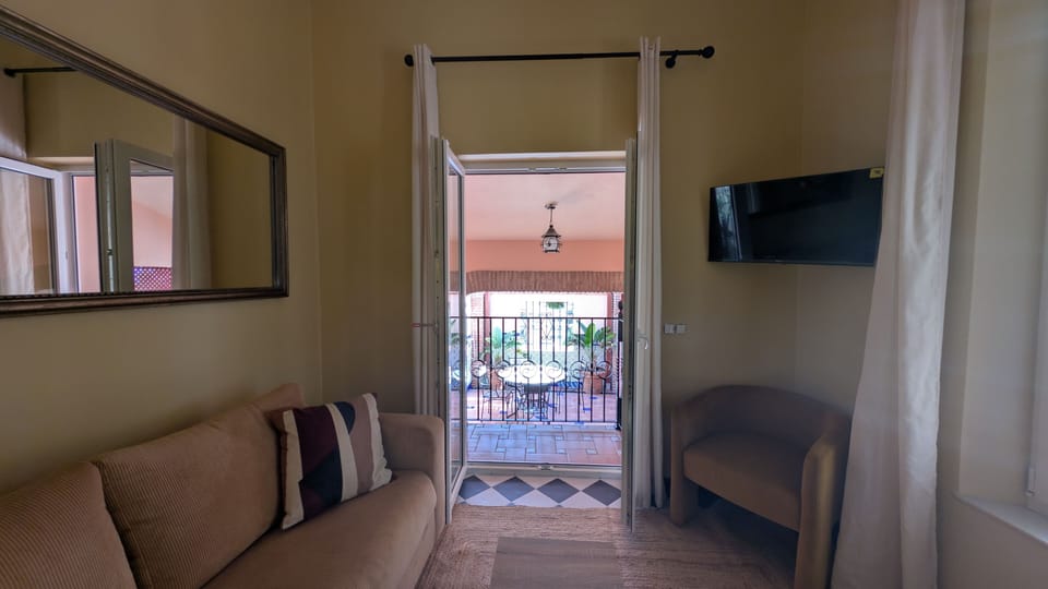 Comfortable living and sleeping space with a sofa, TV, air conditioning, and direct access to the private terrace.