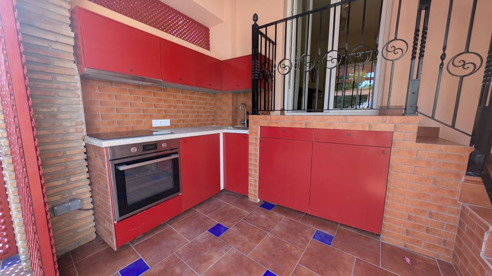 Private terrace featuring a fully equipped outdoor kitchen with an oven, induction hob, fridge, and washing machine.