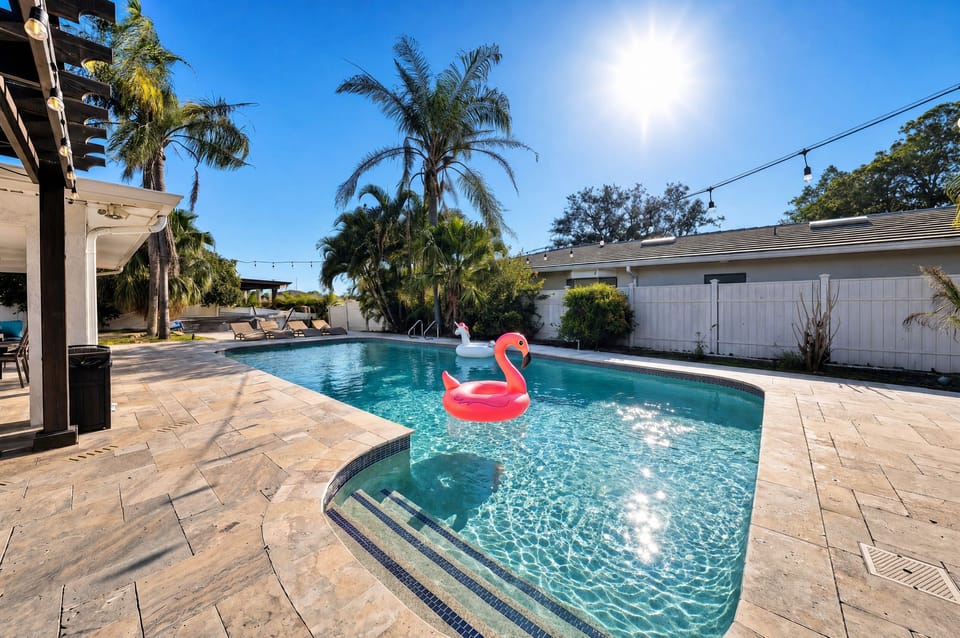 Turquoise pool water glows under swaying palms and string lights, with a playful flamingo float setting the vacation tone.