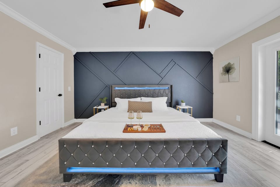Soft natural light and a dramatic geometric accent wall give the primary suite a boutique-hotel feel
