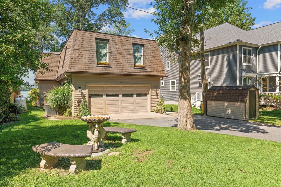 Landscaped front yard with stone bench and birdbath