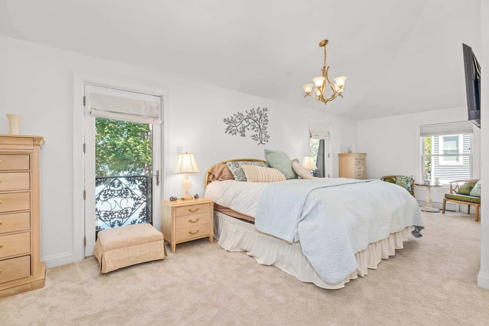 Bedroom with king bed, chandelier and balcony door