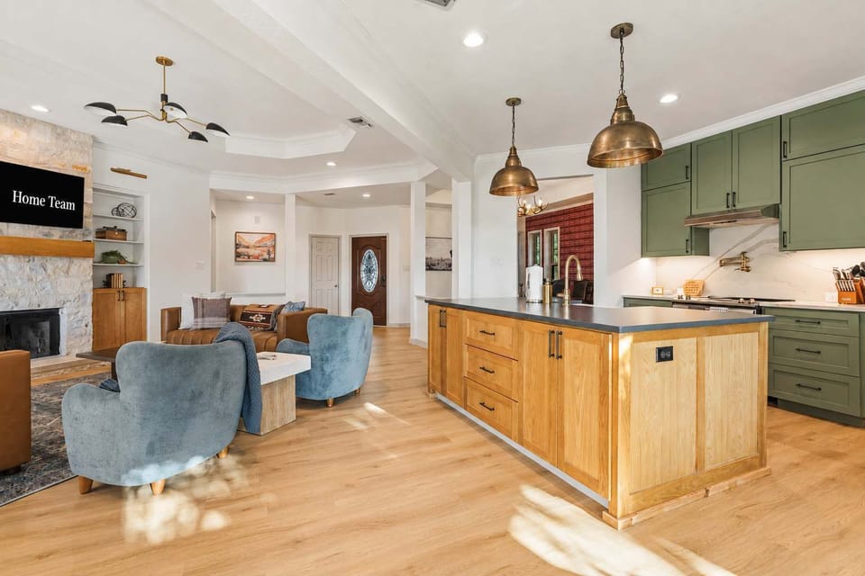 A chef's kitchen with a big island, sage cabinetry, and space for everyone to pitch in.