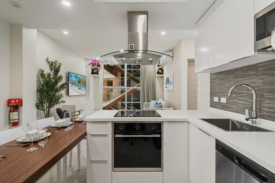 Stainless accents and sleek cabinetry give this kitchen a crisp look, while the practical layout keeps breakfast, snacks, and shared dinners simple to prepare with ease