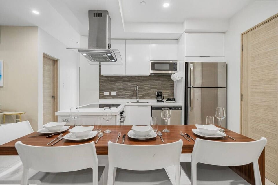 Modern appliances and a stylish dining setup bring the kitchen and dining area together, making it easy to prepare meals, share snacks, and gather around the table