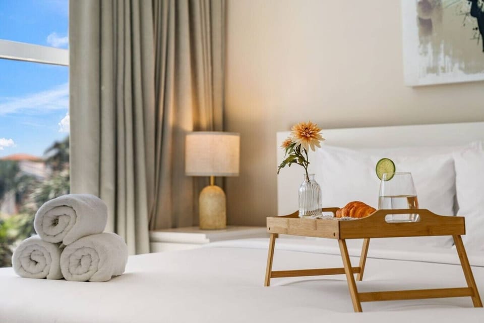 Fresh towels, airy styling, and a neatly arranged breakfast tray add a thoughtful touch to this master bedroom, making slow mornings feel especially easy and relaxed