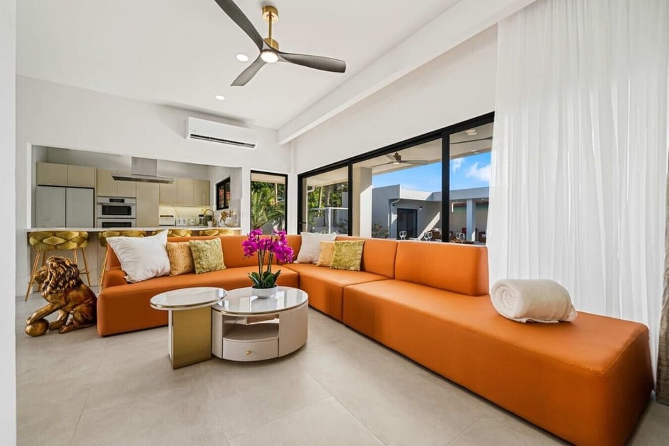 Soak in the bright, tropical atmosphere of this modern living space, complete with vibrant seating and inviting views perfect for unwinding