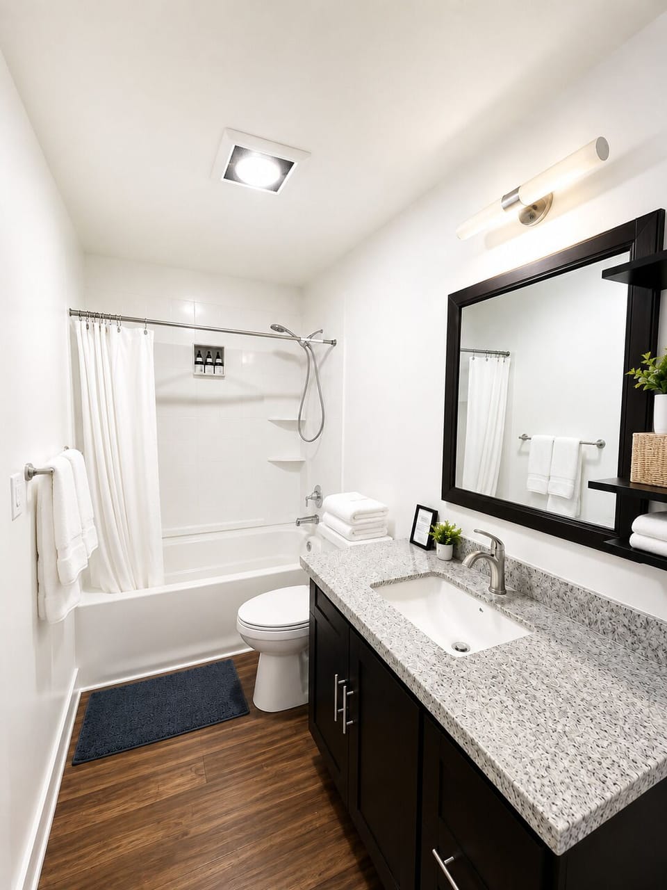 Bright modern bathroom with granite vanity and tub-shower combo