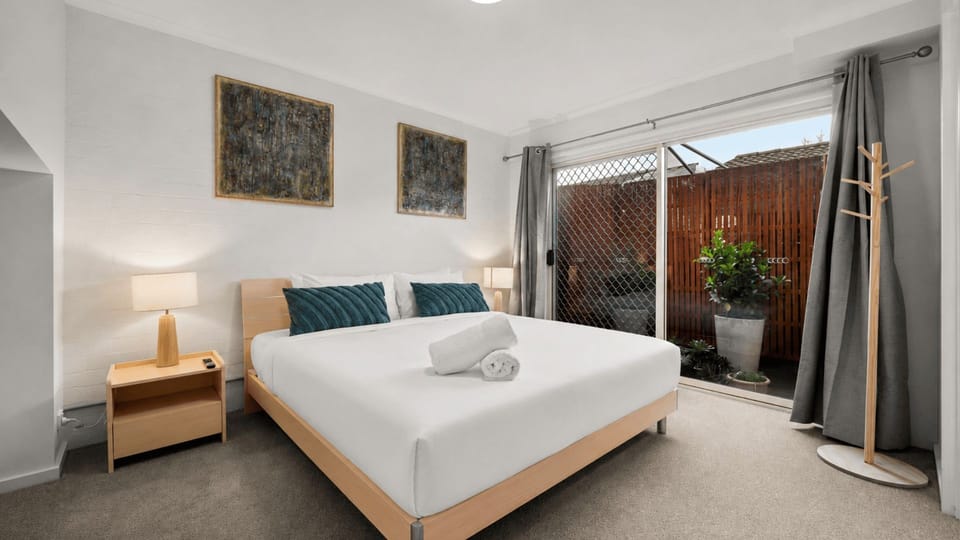 Bright bedroom with sliding glass doors opening to natural light and outdoor views