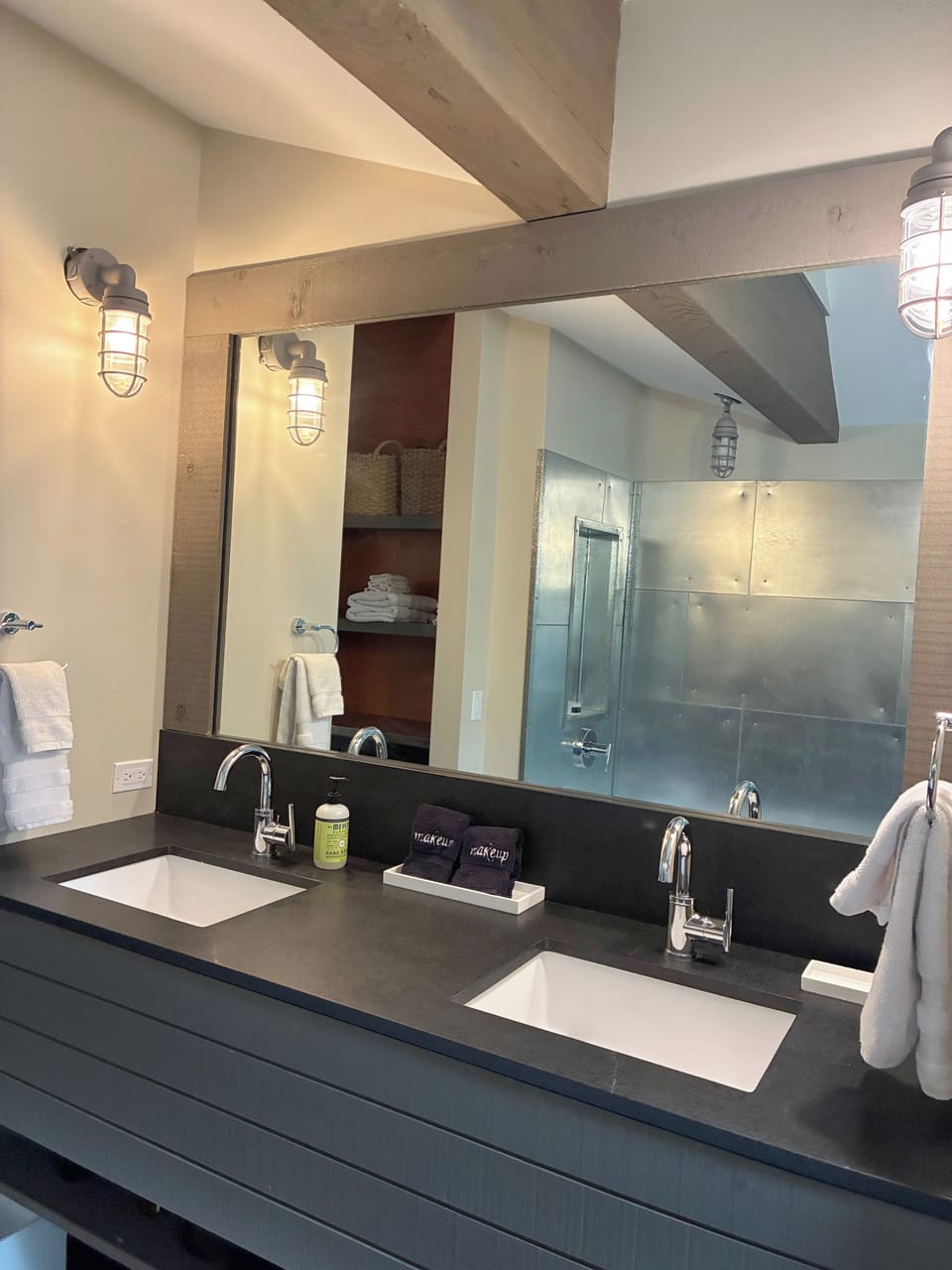 Refresh in your spa-inspired bathroom with dual vanities, modern fixtures, and exposed beam details that blend rustic charm with contemporary comfort.