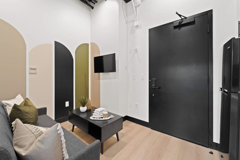 🚪 A striking black entry door—modern contrast against soft, arched wall detailing.