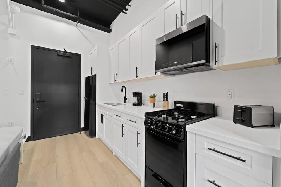 🍳 Black-and-white kitchen finishes with open shelving—compact, stylish, and fully equipped.