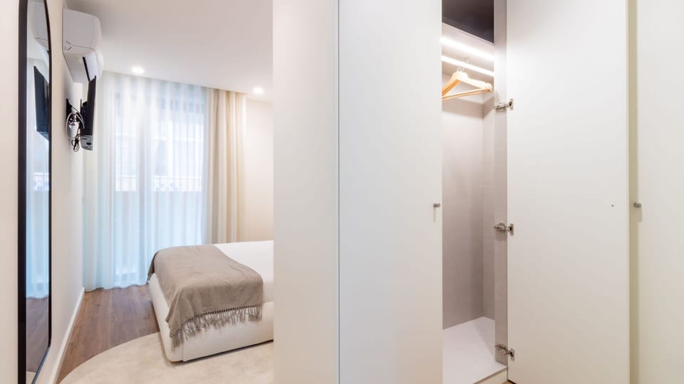 Relax in comfort in the stylish living area, featuring a large smart TV perfect for unwinding with movies or shows after a day of exploring. Thoughtful décor, including a full-length mirror and elegant plants, adds a touch of home to your vacation. #CozyL