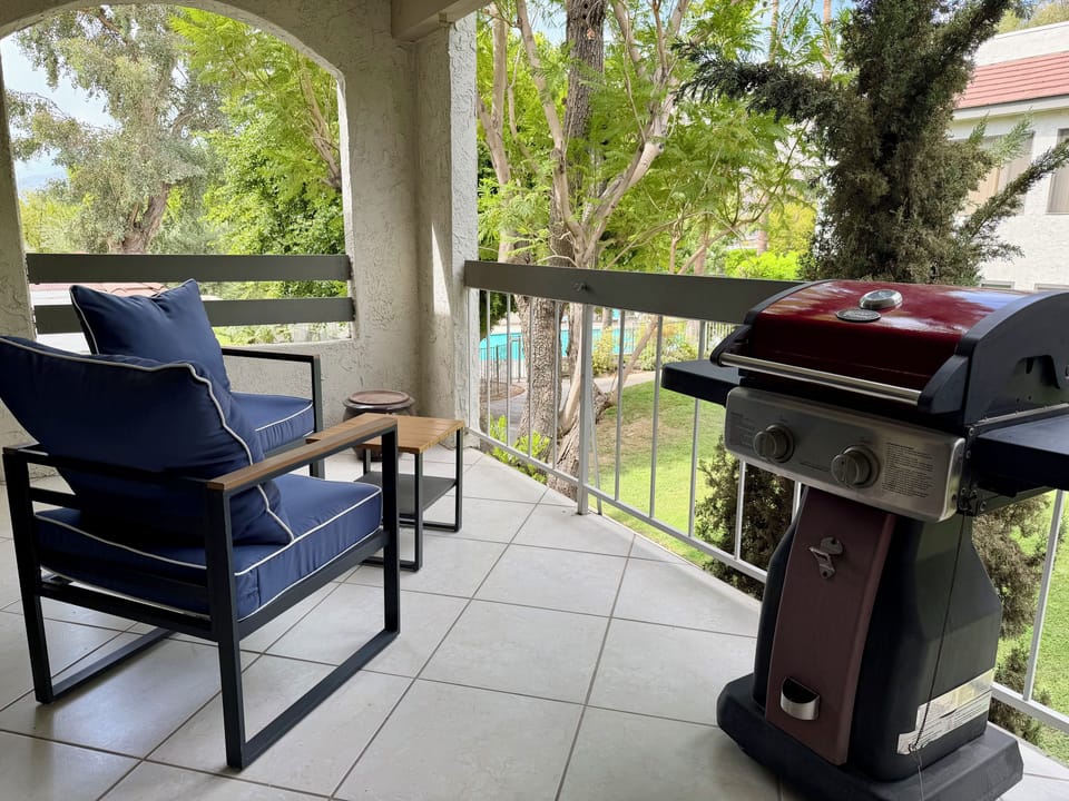 Private balcony with outdoor seating and a convenient gas grill