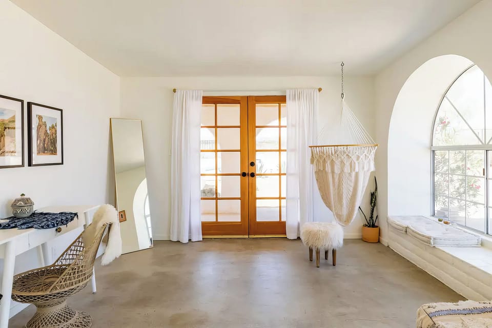 French doors to the patio, a hammock chair, a desk.