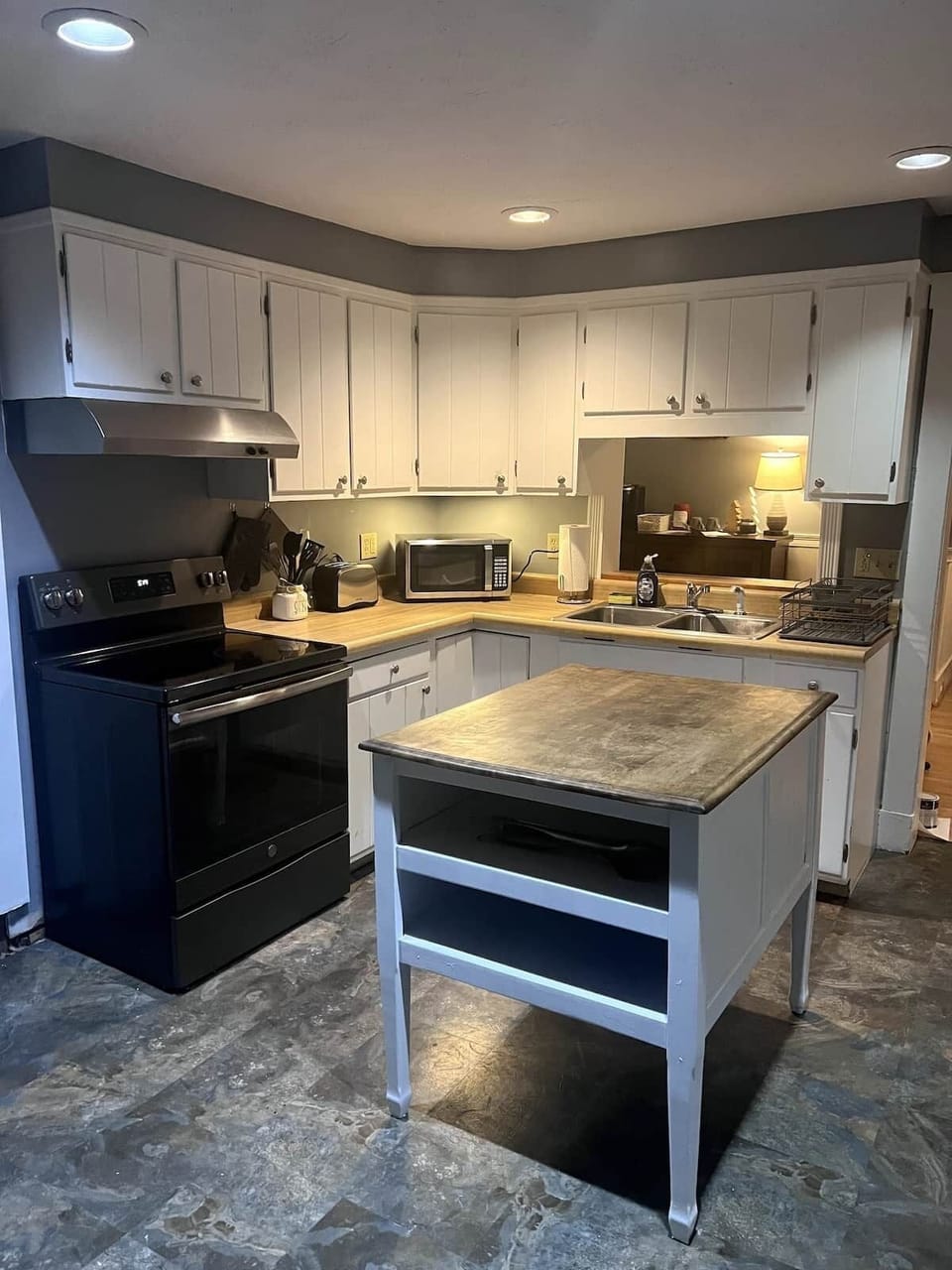 Kitchen features an electric new stove, microwave, there is a toaster over and plenty of pots and pans for your use! Make yourself at home and cook up a delicious meal!
