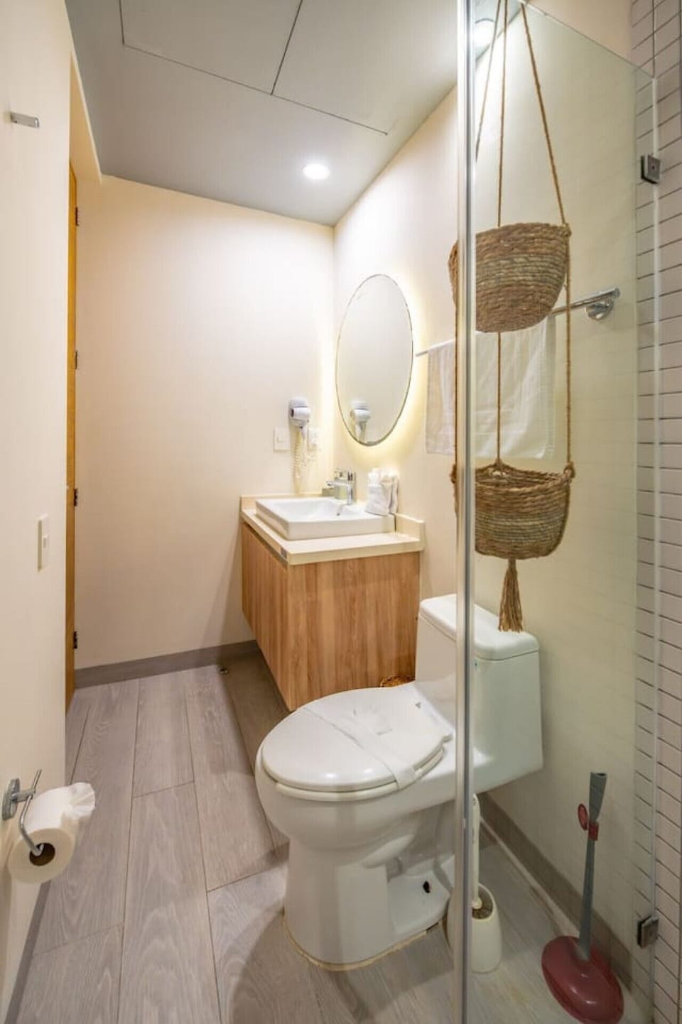 Modern bathroom with vanity, mirror, toilet, and a spacious glass-enclosed shower.