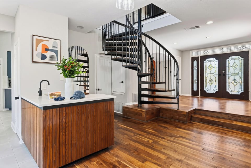 Open kitchenette and entryway with a spiral staircase.