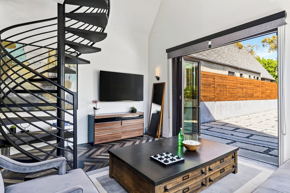 Second living room with spiral stair, TV, and direct access to the patio.