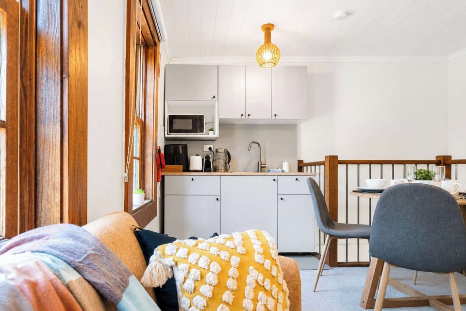 Enjoy a quiet night's sleep in a bright bedroom fitted with crisp linens, plush pillows, wall air conditioning, and a luggage rack
