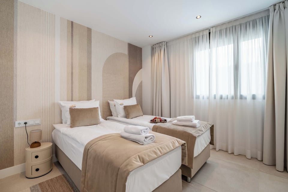 Trzecia sypialnia wyposażona jest w dwa pojedyncze łóżka o wymiarach 80 × 200 cm. Jasne wnętrze zapewnia komfortowe warunki do wypoczynku, a hotelowa pościel i komplet poduszek dopełniają wyposażenie sypialni.