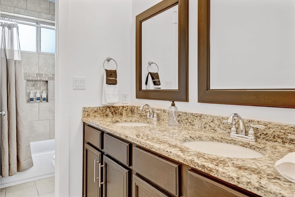 Ensuite bathroom w/ granite counter & tiled tub/shower combo