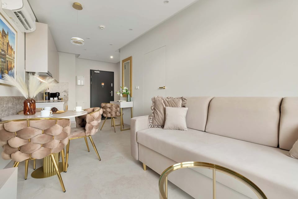 A refined lounge area with a curved sofa, round coffee table, and dining space nearby. Neutral tones and contemporary décor create a sophisticated atmosphere.