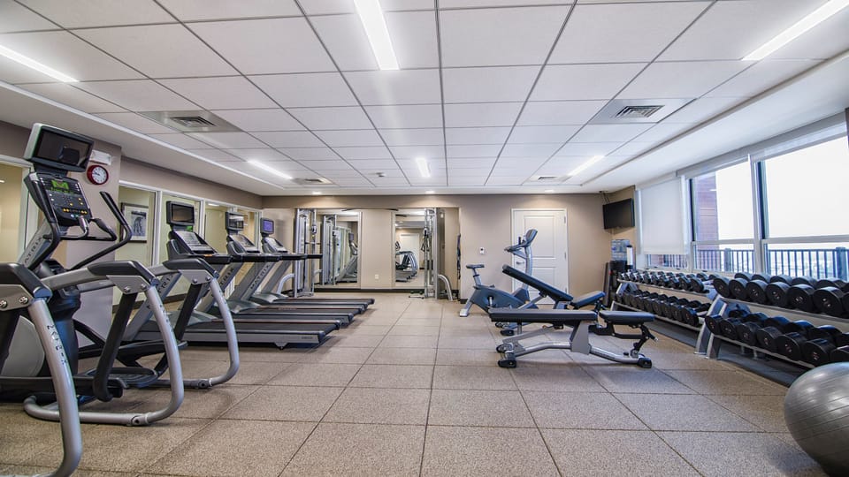 Fitness center with cardio machines, free weights, and exercise equipment.