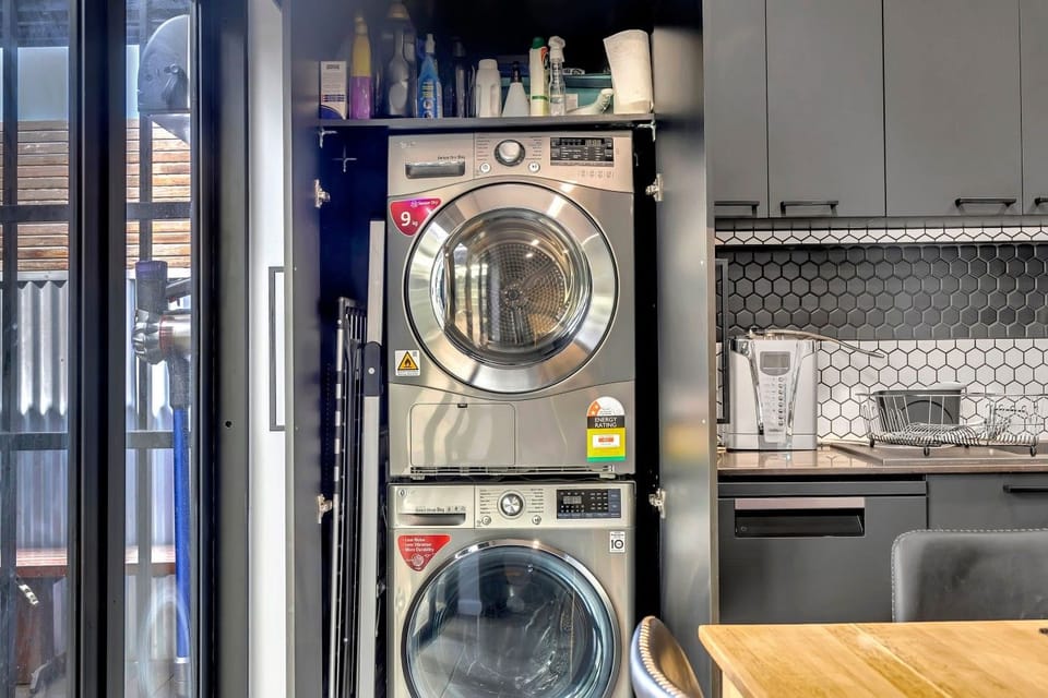Stacked washer/dryer tucked beside the kitchen.
