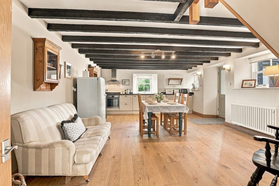 Woodworkers open-plan kitchen and dining area with exposed ceiling beams