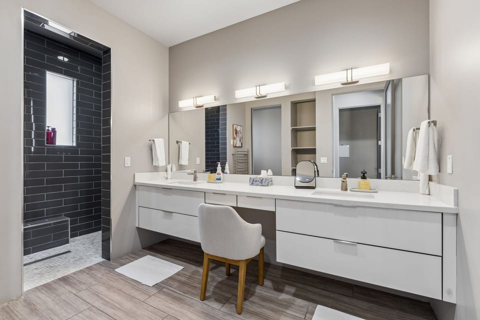 Ensuite bathroom with dual vanity sinks, vanity, and a walk-in shower