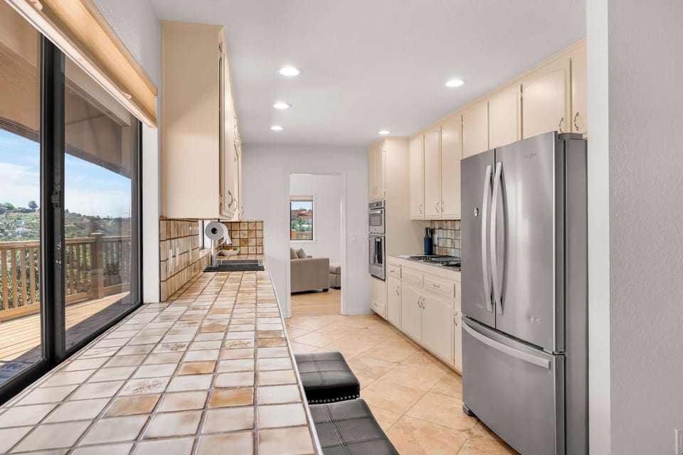 Large windows and glass doors bring natural light and scenic views into the kitchen