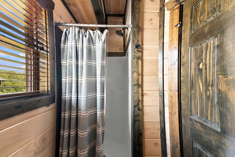 Rustic cabin bathroom with bright window and cozy wood-accented shower