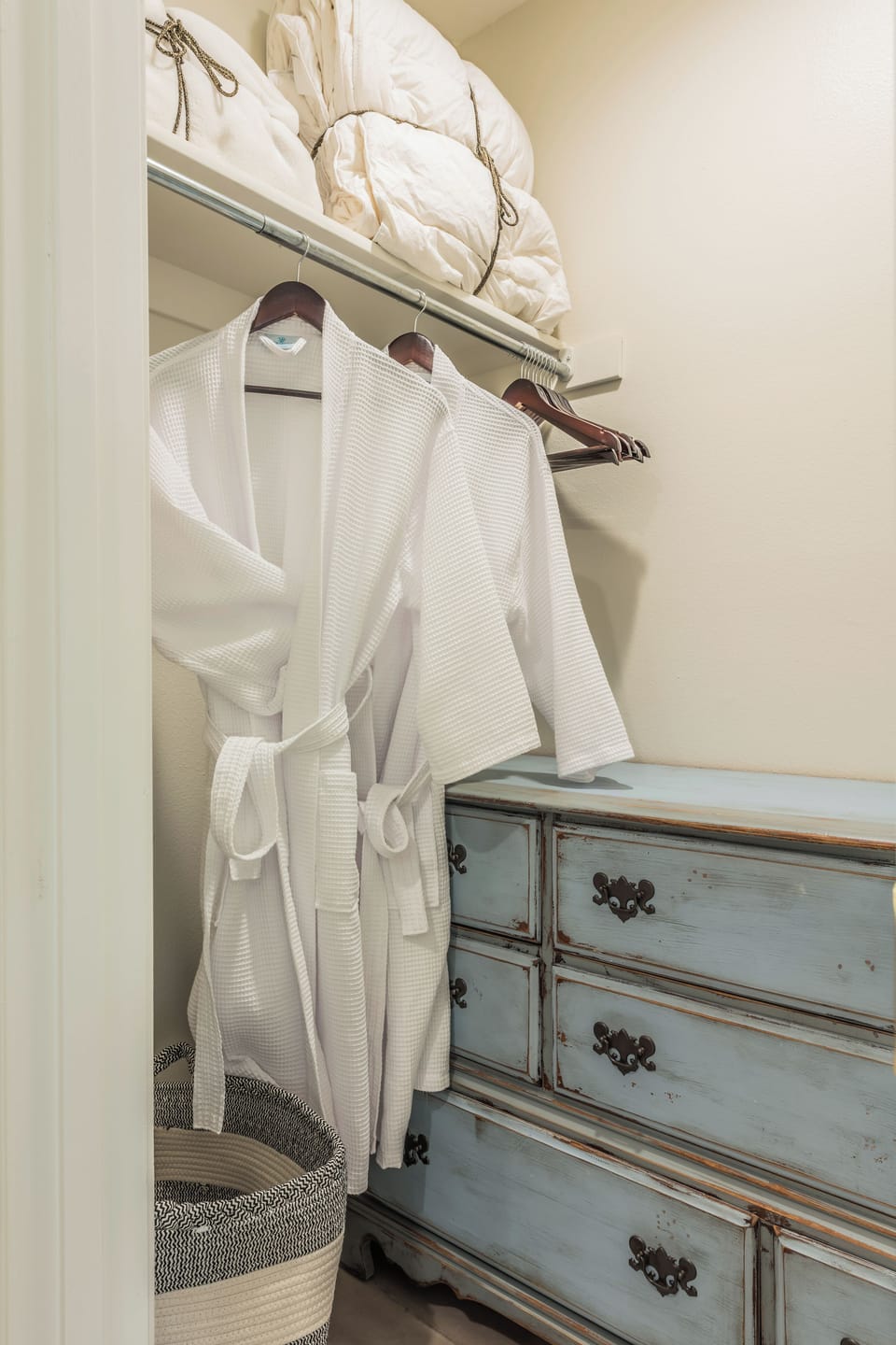 Walk-in closet with dresser storage, linens and guest robes
