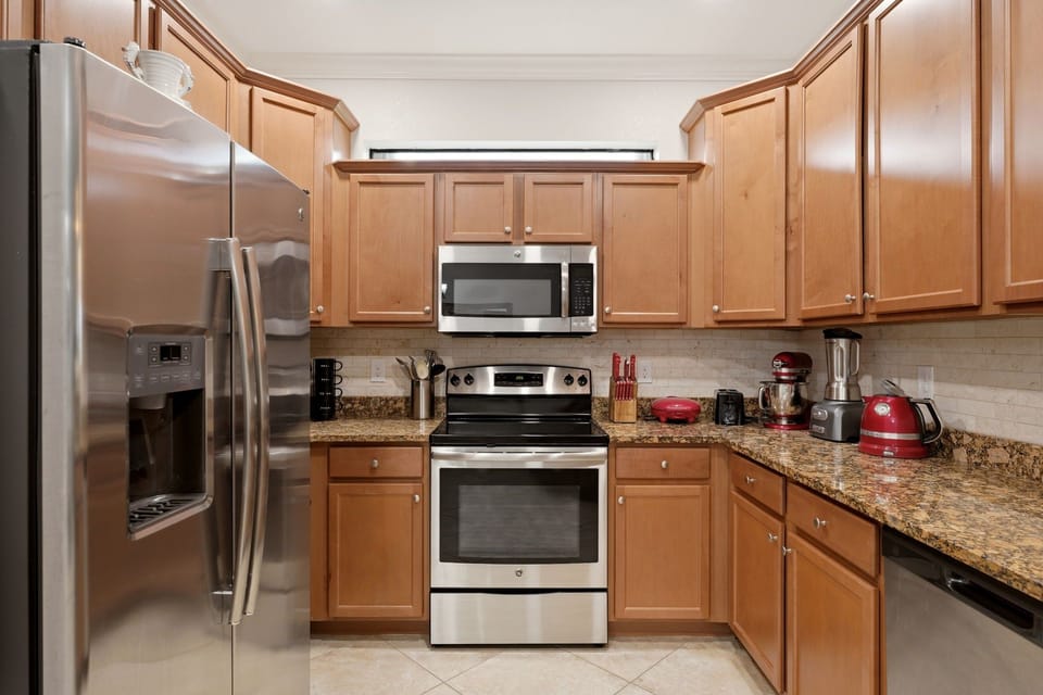 A fully equipped kitchen with granite counters and stainless appliances — everything you need to cook a real meal after a day on the course.