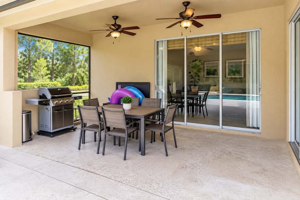 Spacious screened-in patio with al fresco dining for six, dual ceiling fans, and a gas grill for cookouts