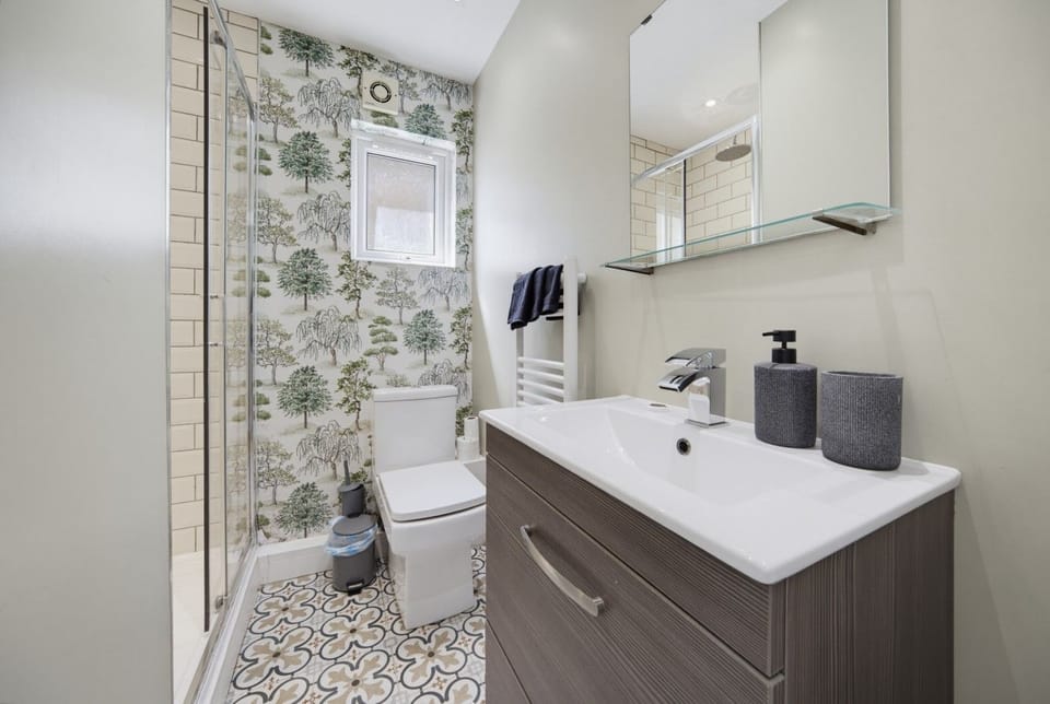Bathroom basin and WC, finished with patterned tile details.