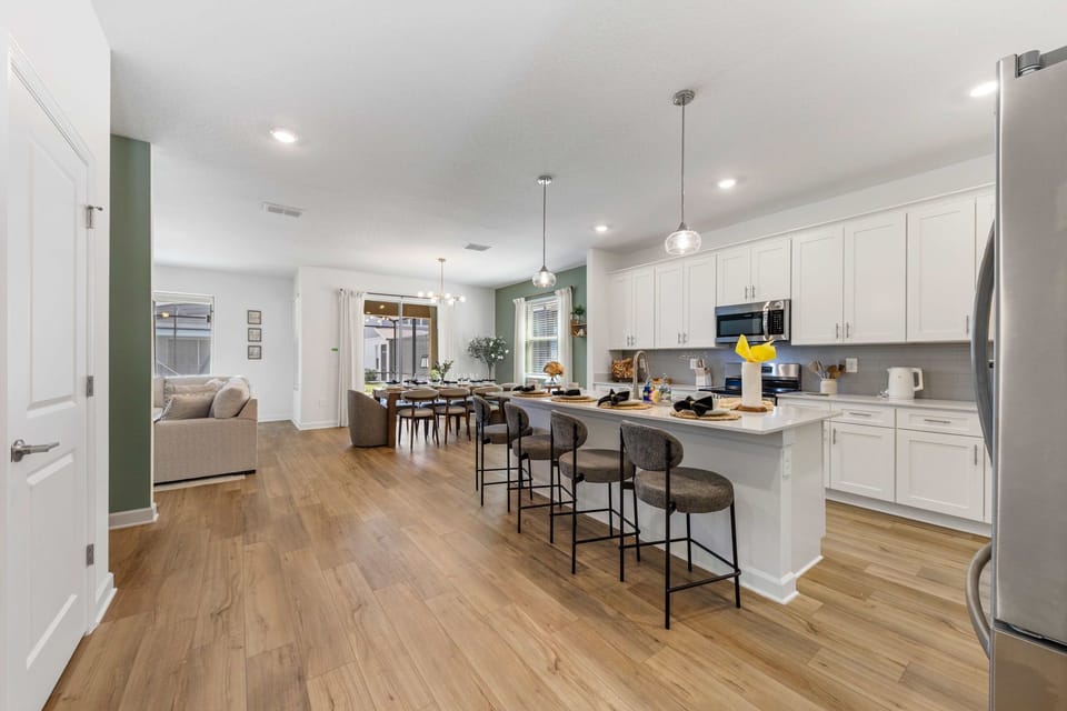 Gather in this bright open-concept kitchen with quartz counters, island seating, and a welcoming dining area-perfect for meals and memories.