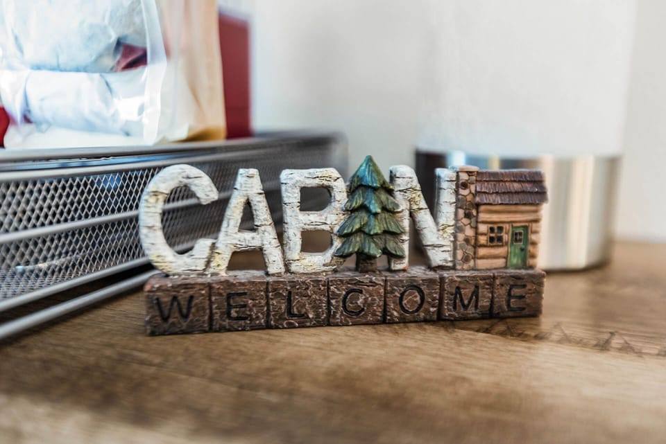 A charming cabin-themed welcome sign greets you, setting a cozy, rustic tone for your stay in this thoughtfully decorated space.