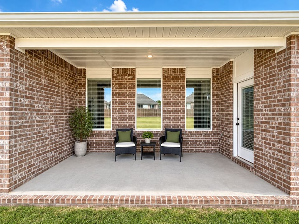 Covered brick patio with cozy seating and easy backyard access