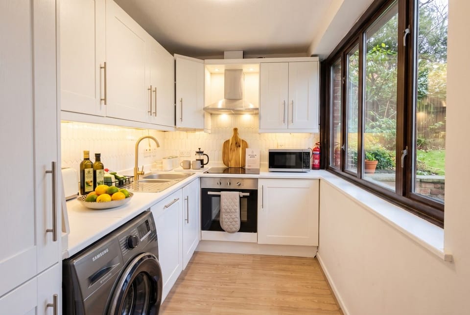 The galley kitchen runs along one wall with a garden view through the windows.