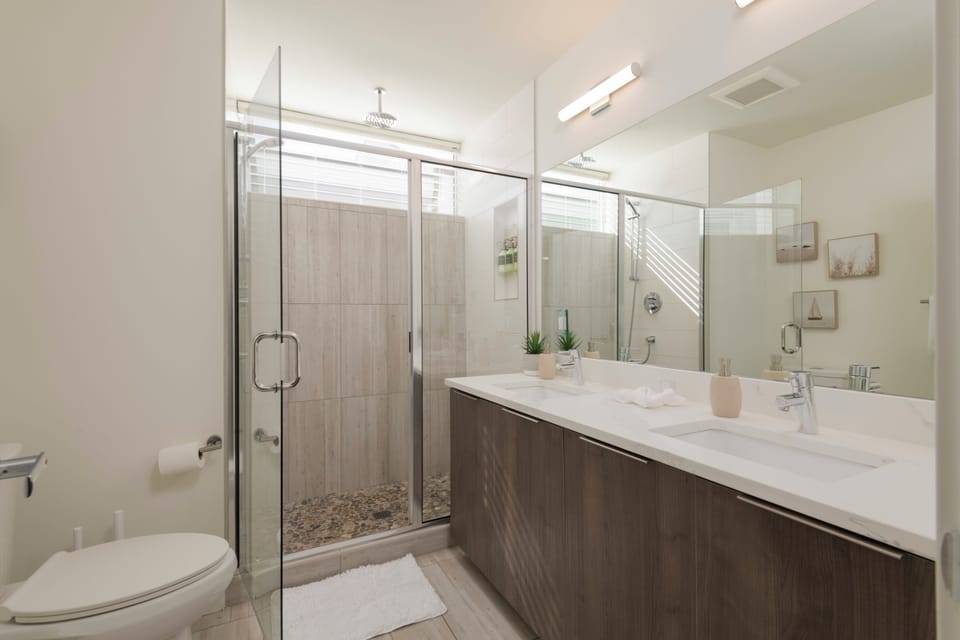 Bright spa-like bathroom with double vanity and glass walk-in shower
