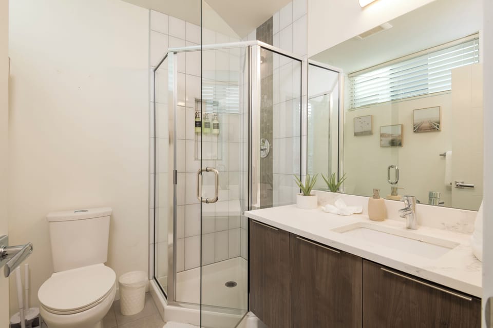 Bright modern bathroom with glass shower and spacious vanity