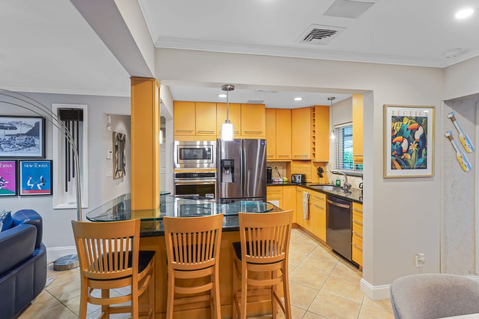 Spacious kitchen featuring a breakfast bar with stools and an open layout to the living area.