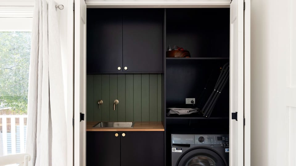 Convenient laundry cupboard featuring built-in shelving and appliances.