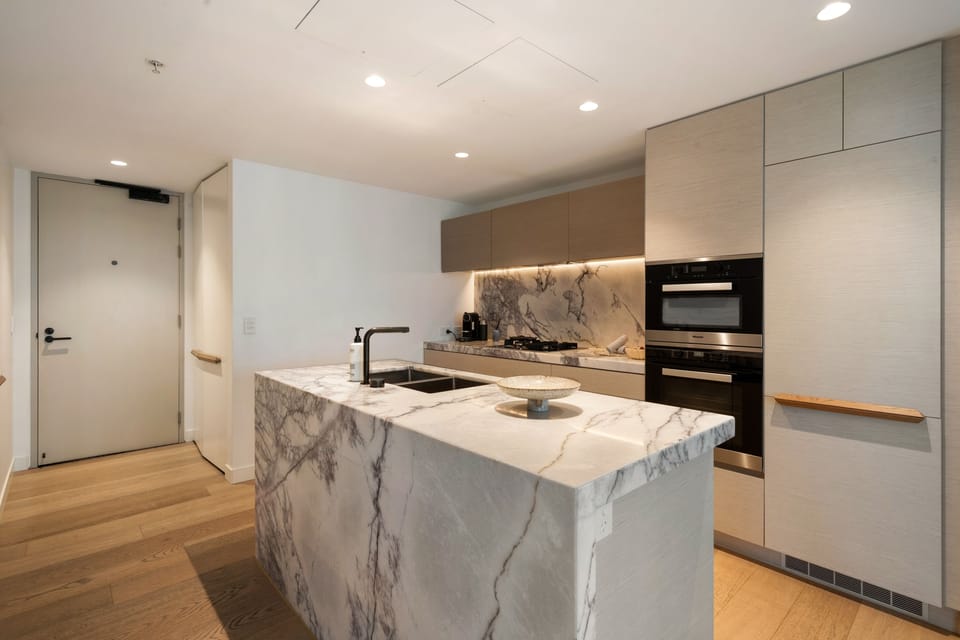 The main bedroom: a large bed, wall-mounted TV and its own sliding door onto the west balcony