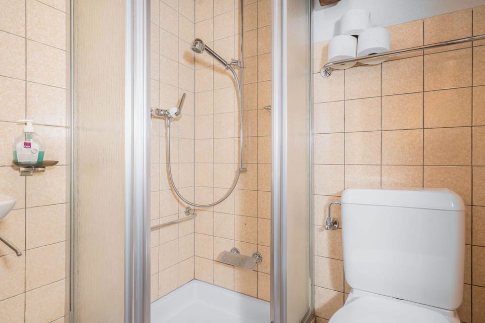 Shared bathroom with shower and practical facilities for a comfortable stay.
